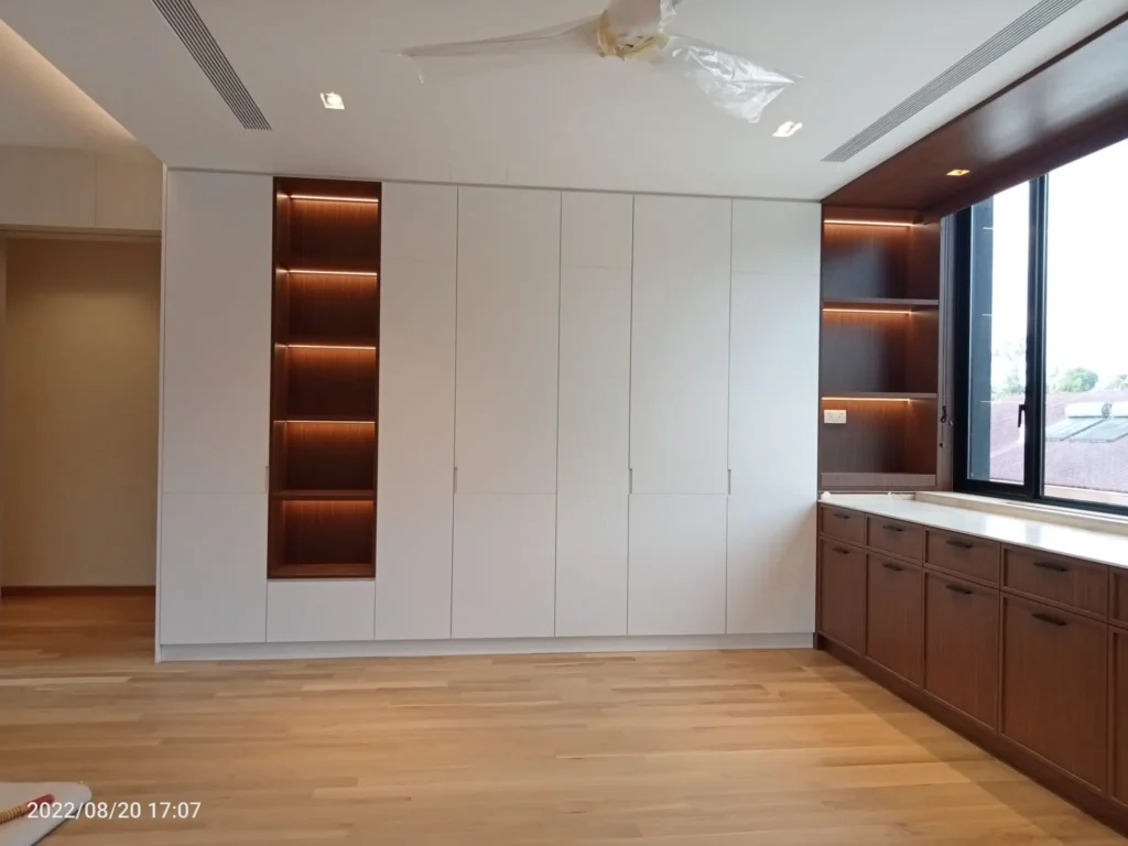 A room featuring wooden floors and cabinets, showcasing a modular wardrobe design in Singapore.