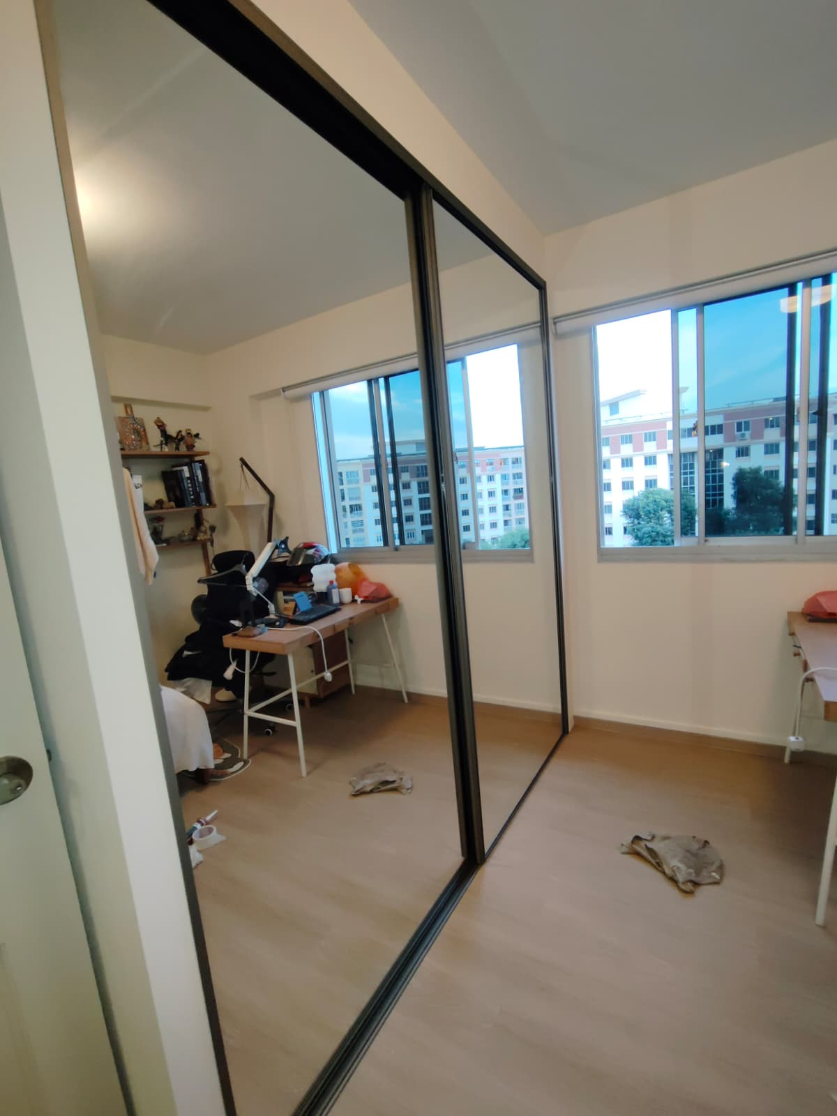 Side A: clear mirror glass sliding doors of double-sided wardrobe in Tampines HDB