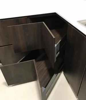 A well-organized kitchen with a sink, drawers, and corner organizers for maximizing space.